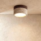 Clérachic ceiling light with a dark walnut band over a speckled travertine-look drum, mounted flush overhead.