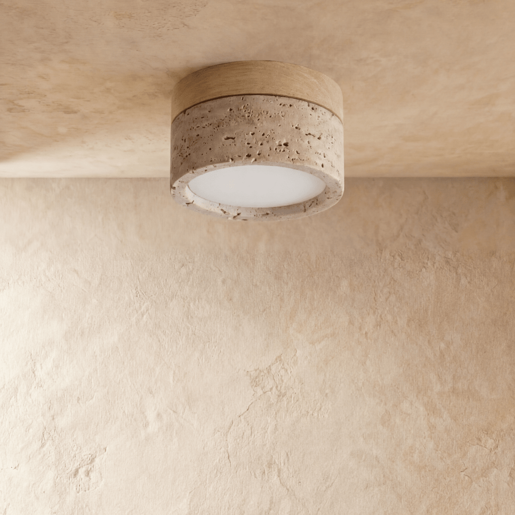 Clérachic ceiling light with a light wood band over a speckled travertine-look drum, glowing warm overhead.