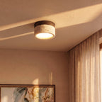 Clérachic ceiling light in walnut glowing near a framed floral painting on the wall below.