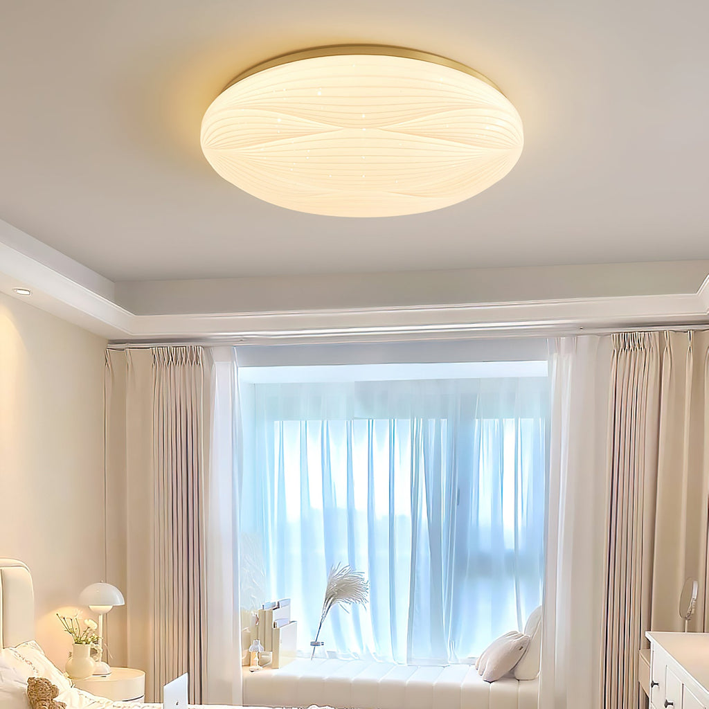 This Clérachic ceiling light glows warm above a bedroom with a window seat and sheer curtains, its shade showing fine wave lines.