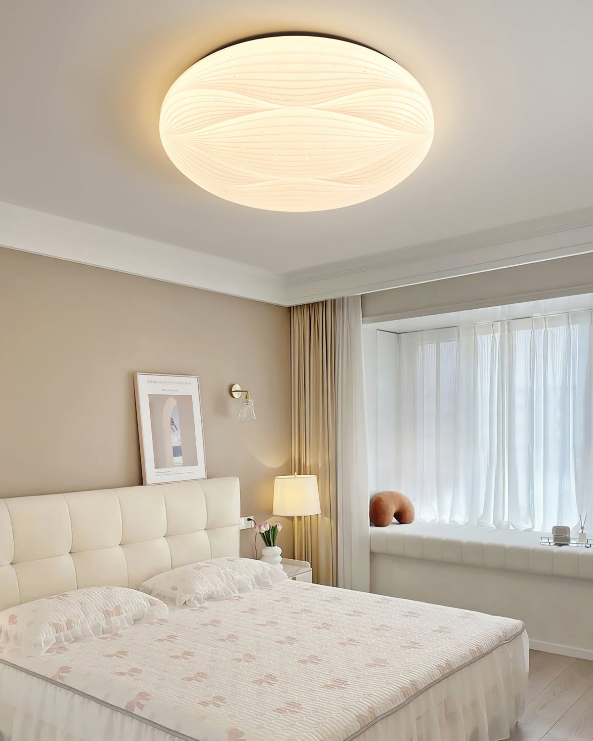 This Clérachic ceiling light with a black rim glows above a white tufted headboard and a pink floral duvet.