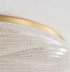 Close view of the gold rim and the grainy, crystal-textured shade on this Clérachic ceiling light.