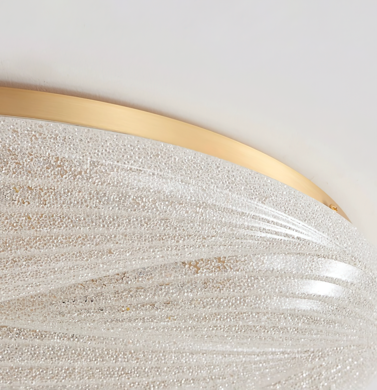 Close view of the gold rim and the grainy, crystal-textured shade on this Clérachic ceiling light.
