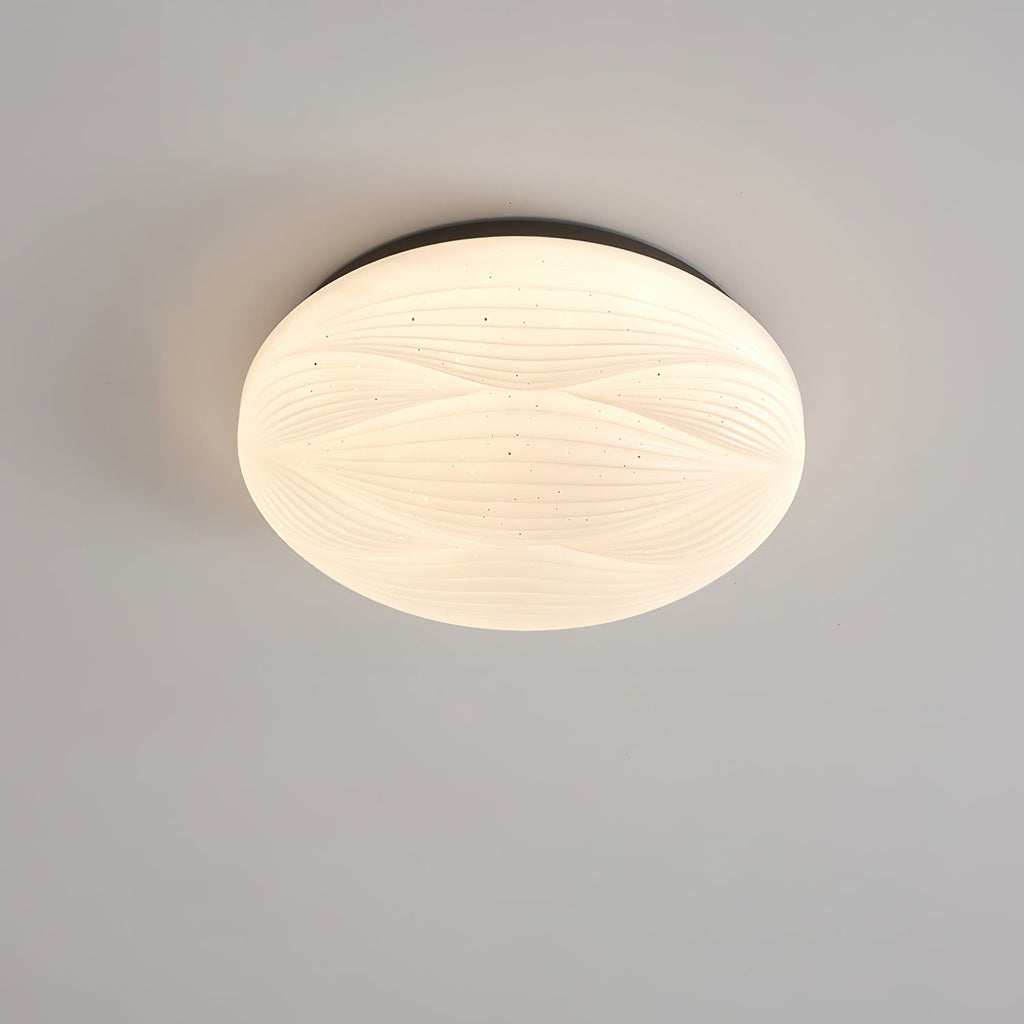 A small black-rimmed Clérachic ceiling light lit with a white ribbed shade against a grey ceiling.
