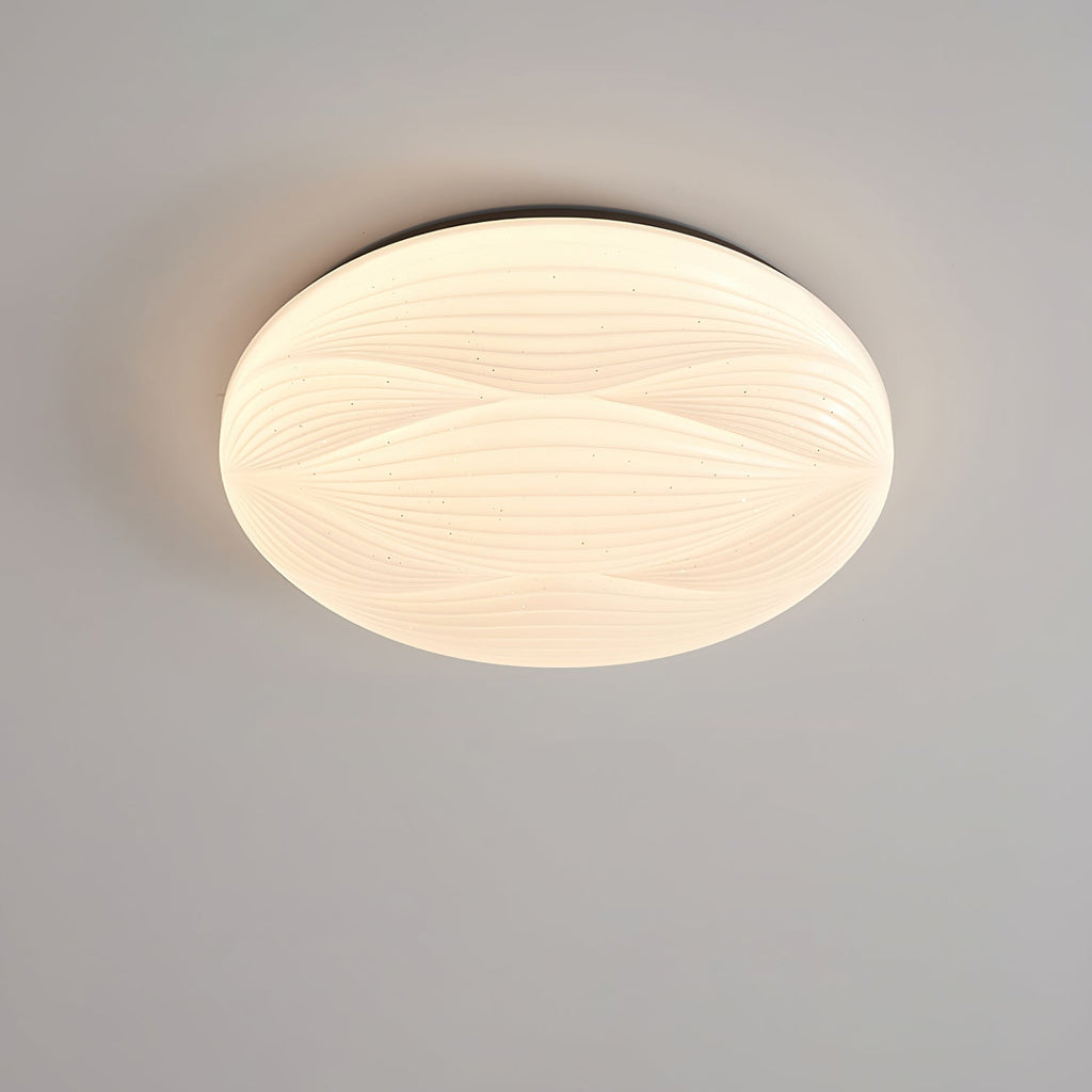 Lit Clérachic ceiling light with a dark rim and a ribbed white shade, seen from below on a grey ceiling.