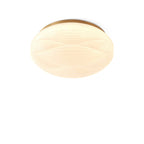 This Clérachic ceiling light has a gold rim and a lit ribbed shade, shown from slightly below on a white backdrop.