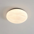 The black rim frames the glowing ribbed shade of this Clérachic ceiling light, seen from below on grey.