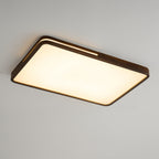 Rectangular walnut ceiling light from Clérachic glowing warm on a grey ceiling, seen at a steep angle from one corner.