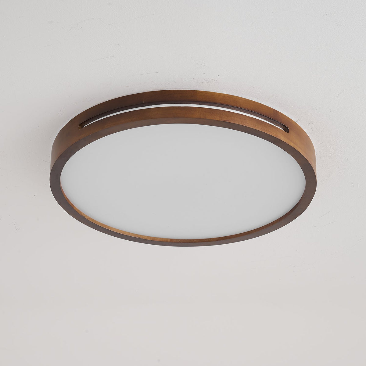 Round walnut-frame Clérachic ceiling light switched off, showing the matt white frosted panel inside the wood ring.