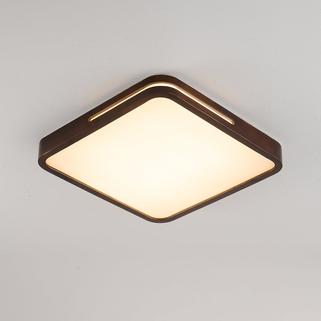 Square dark walnut Clérachic ceiling light with its panel lit warm, set against a softly shaded grey ceiling.
