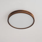 Round walnut-frame ceiling light from Clérachic, unlit, with a slotted wood rim around a flat frosted panel.