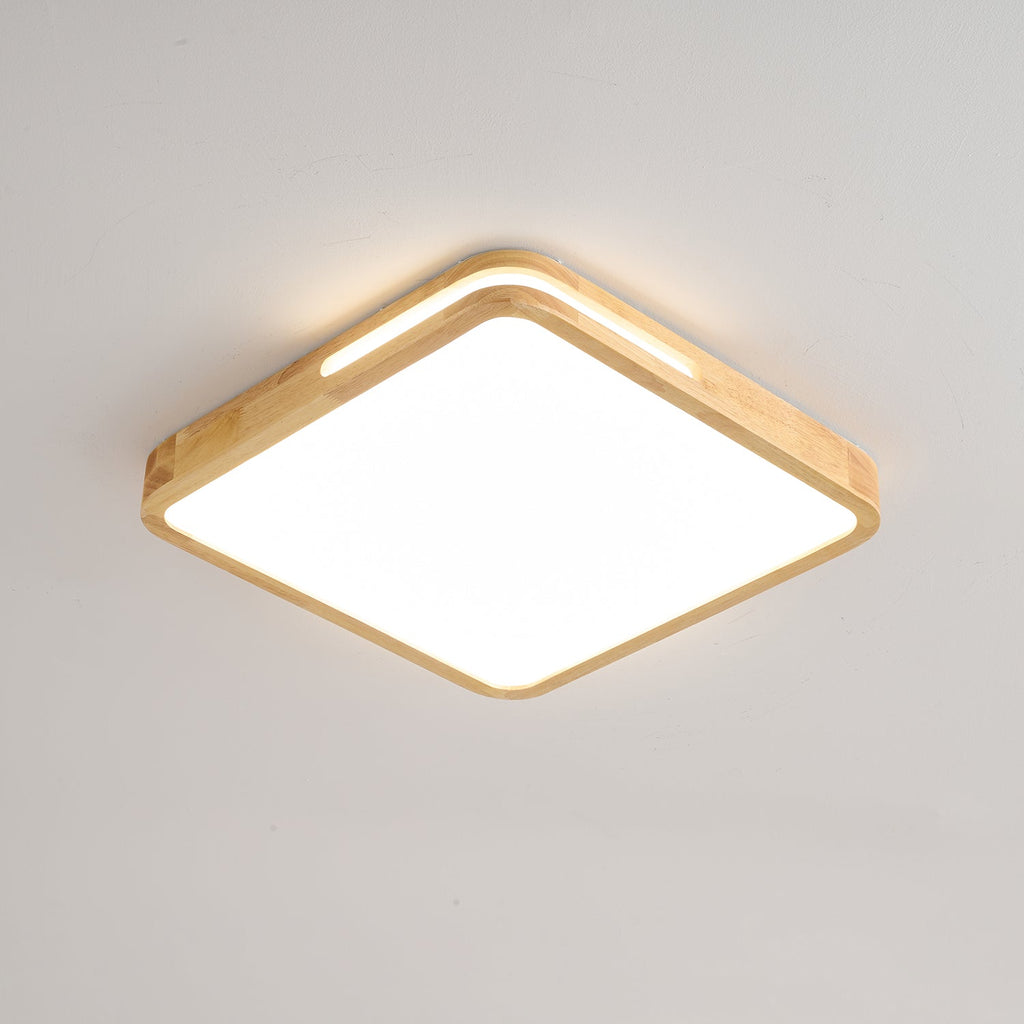 Square Clérachic ceiling light in a light wood finish, switched on, with a glow spilling from the slot in the frame.