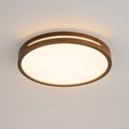 Round walnut ceiling light from Clérachic with a warm glow through the rim slot and a bright frosted panel below.