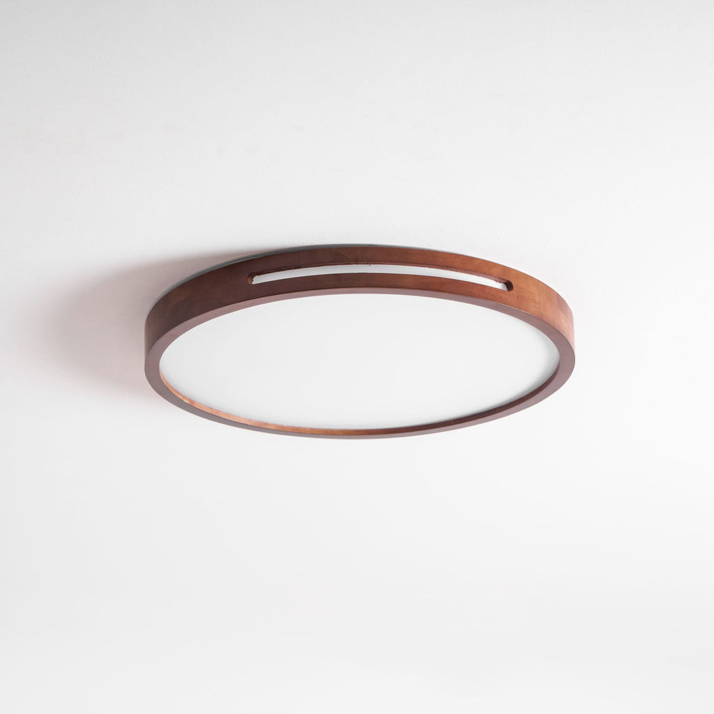 Round walnut ceiling light from Clérachic, switched off, photographed at a low angle to show the slim 5.5 cm depth.