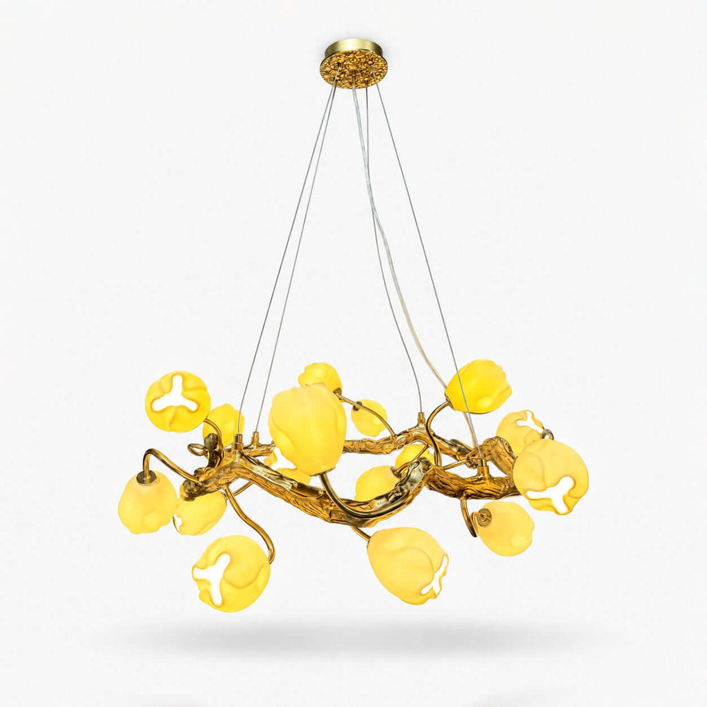 Gold branch chandelier from Clérachic with softly lit yellow-white flower shades on a ring of twisting stems, hung on thin cables against white.