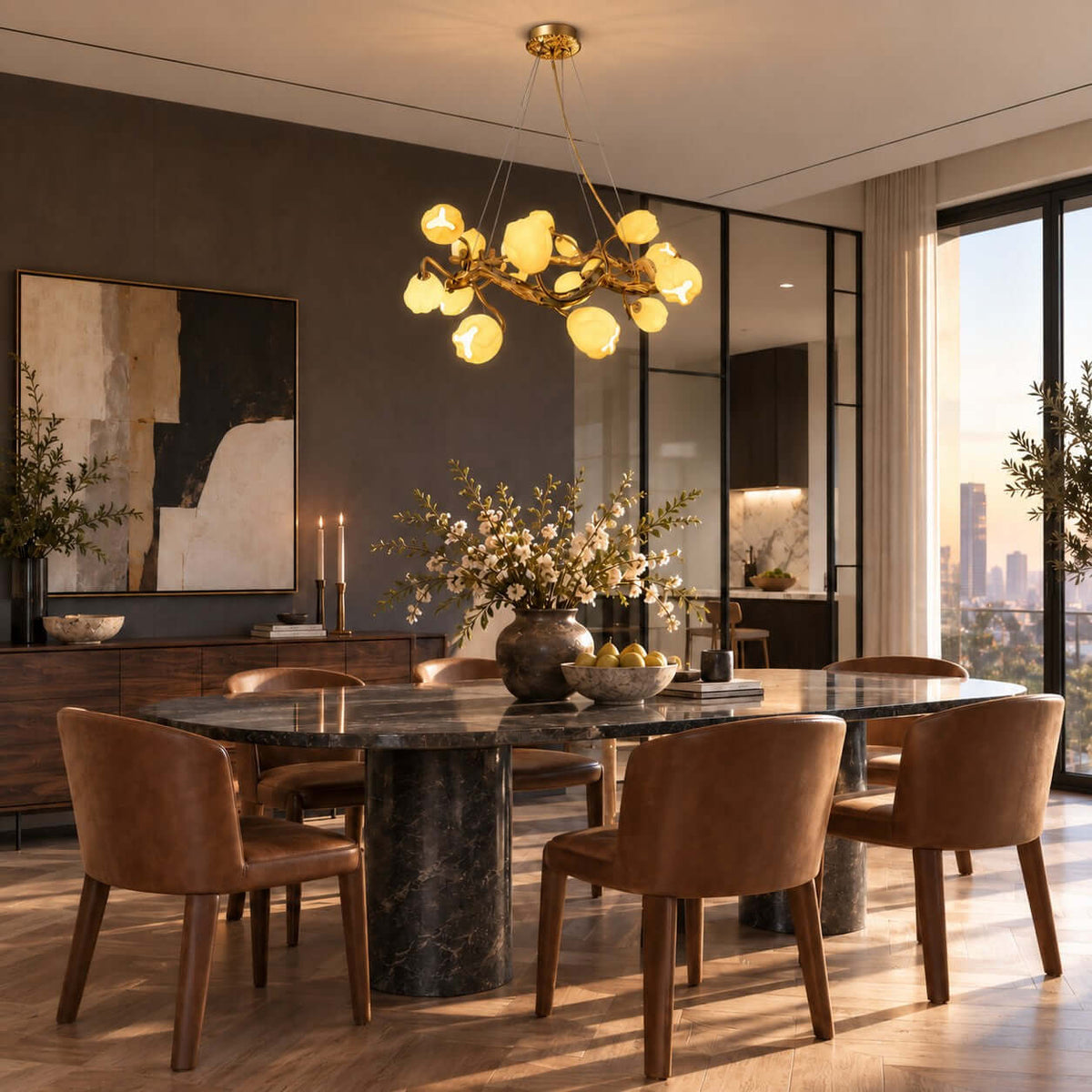 Lit over a dark marble dining table and tan leather chairs, this Clérachic gold chandelier sits in front of a large abstract canvas.