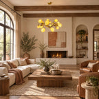 This Clérachic flower chandelier hangs above a wooden coffee table in a living room with a stone fireplace, leather armchairs and exposed beams.