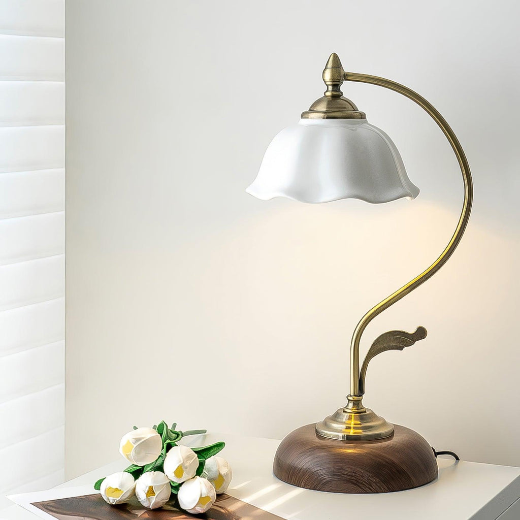 Clérachic table lamp on a white shelf beside a bunch of white tulips, with a window blind and soft daylight behind.