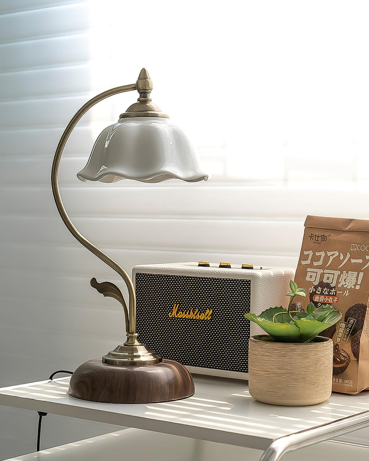 Unlit Clérachic table lamp with a white ceramic shade beside a retro cream speaker and a potted succulent on a white shelf.
