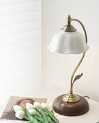 Clérachic table lamp with a white ceramic flower shade beside white tulips and a printed photo, in a bright corner with a window blind.