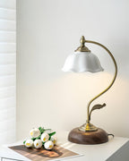 White tulips and a printed photo on a white table beside this unlit Clérachic table lamp, its ceramic shade tipped forward.