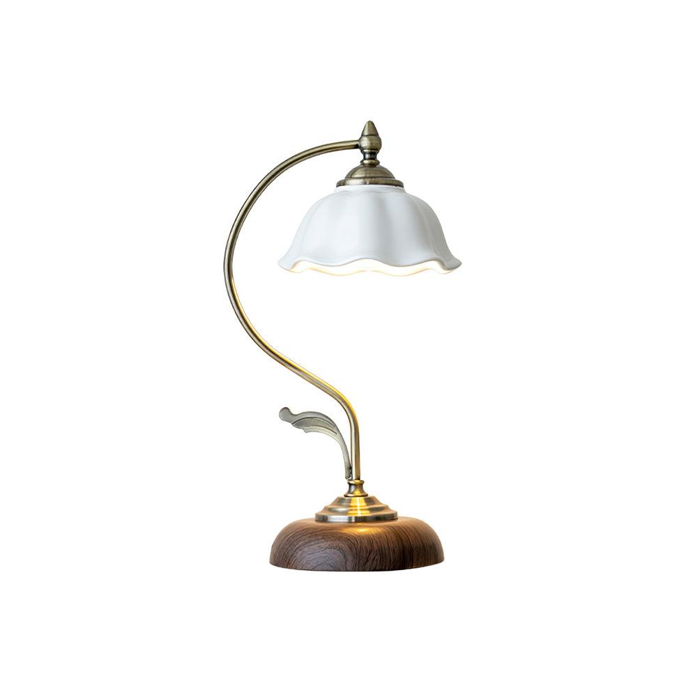 Clérachic table lamp with a white ceramic shade, a curved brass-toned arm and a walnut-effect base, on a plain white background.