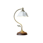Clérachic table lamp with a white ceramic shade, a curved brass-toned arm and a walnut-effect base, on a plain white background.