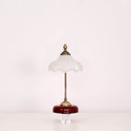 Clérachic table lamp with a frosted glass shade and a straight stem, unlit, on a clear block against a pale backdrop.