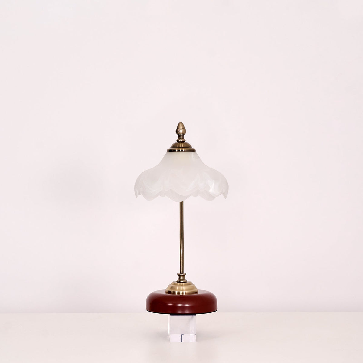 Clérachic table lamp with a frosted glass shade and a straight stem, unlit, on a clear block against a pale backdrop.