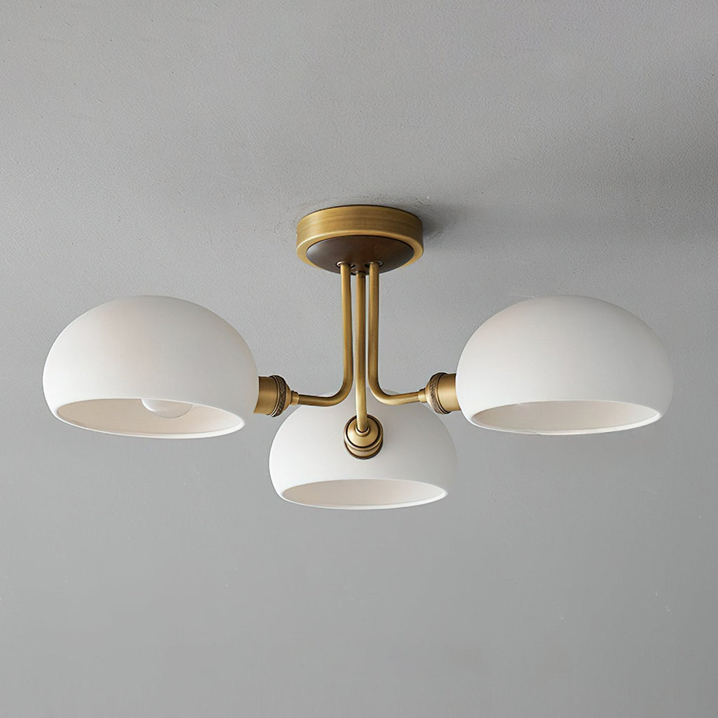 Unlit brass and white ceramic ceiling light from Clérachic against a pale grey ceiling, the shades open downward.