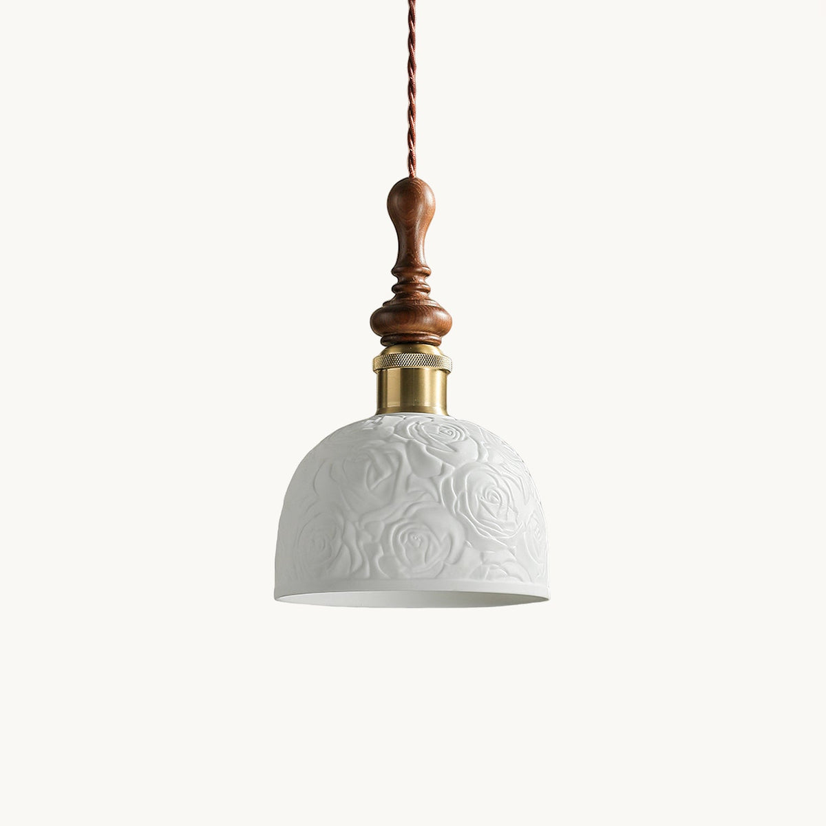A white ceramic Clérachic pendant with a rose pattern in relief, a brass-coloured collar and a turned walnut top, on white.