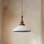 A wide, flared white ribbed ceramic Clérachic pendant, unlit, seen from slightly below to show the bulb inside.