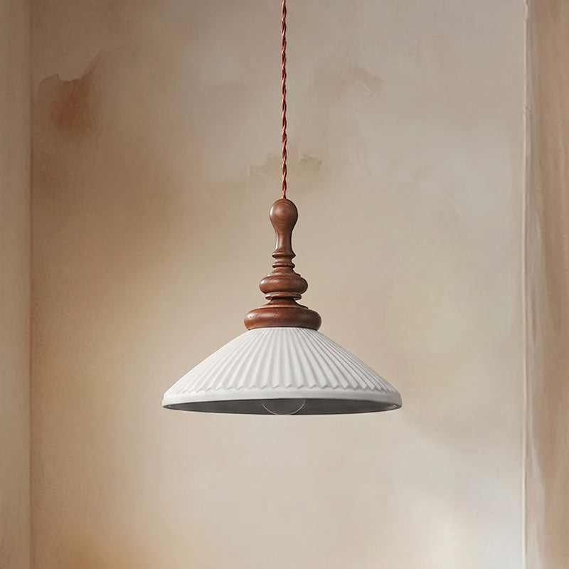 A wide, flared white ribbed ceramic Clérachic pendant, unlit, seen from slightly below to show the bulb inside.