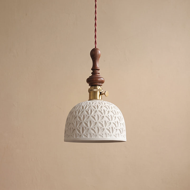 A white ceramic Clérachic pendant with a pierced leaf pattern, a brass switch collar and a turned walnut top.