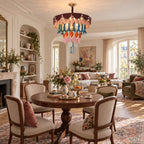 The Clérachic chandelier hangs in a room with a fireplace, arched shelving and a round table, with a living area beyond.