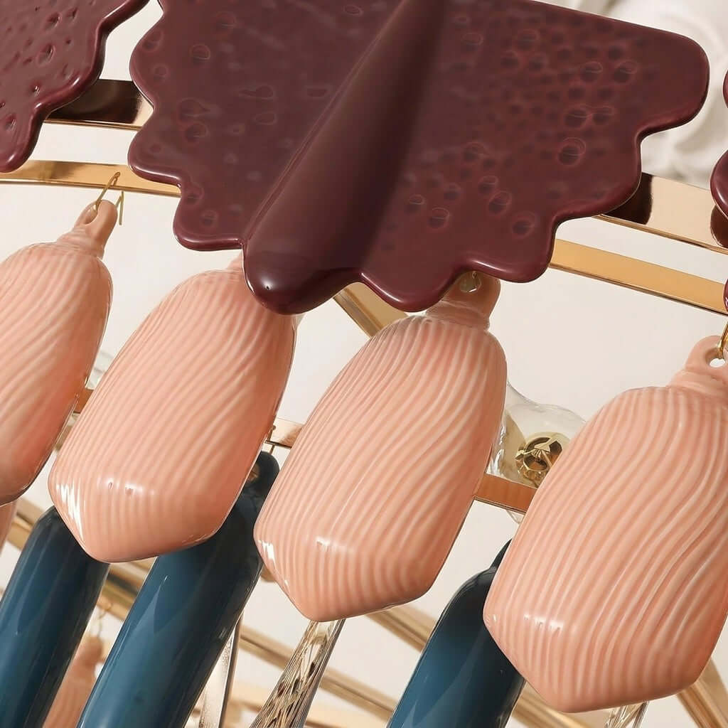 Close view of the dark burgundy glazed scalloped cap and the ribbed pink ceramic drops on this Clérachic chandelier.