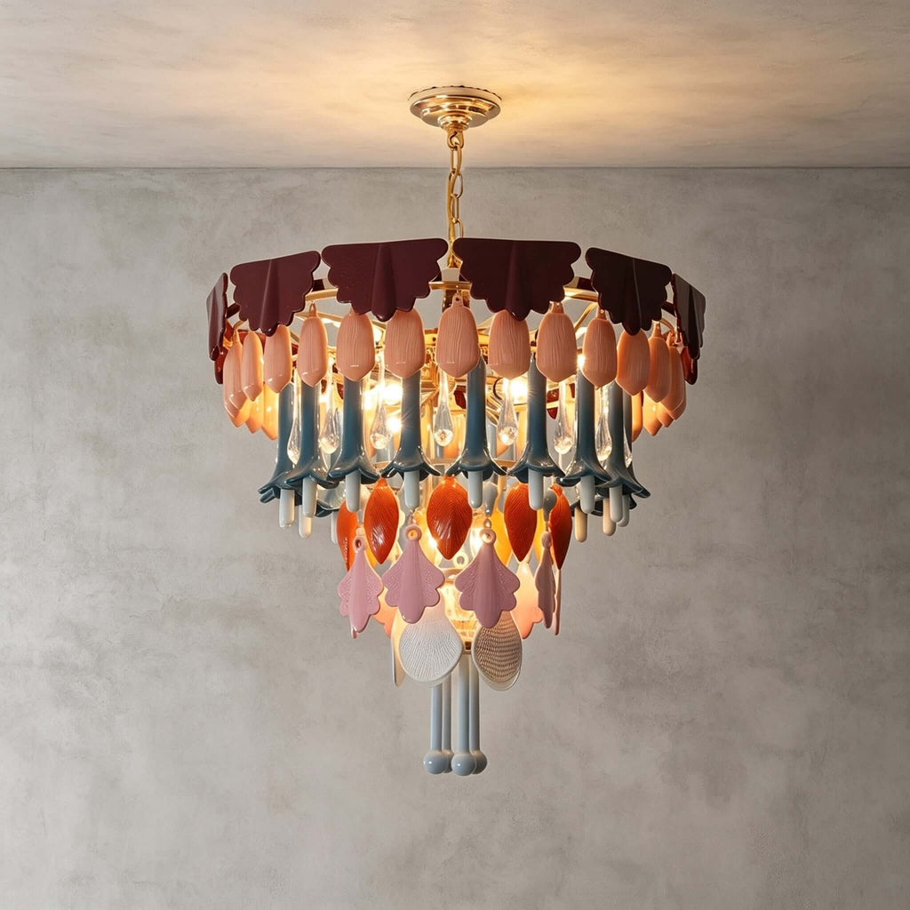 A round Clérachic chandelier with tiers of ceramic and glass drops, lit against a grey plaster wall and ceiling.