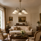A Clérachic five-light chandelier with white ceramic shades in a cream sitting room, above a sofa and low wooden coffee table.