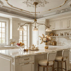 Three-light Clérachic chandelier on long, curving brass arms, hung in a cream kitchen with a marble island and ornate plaster ceiling.