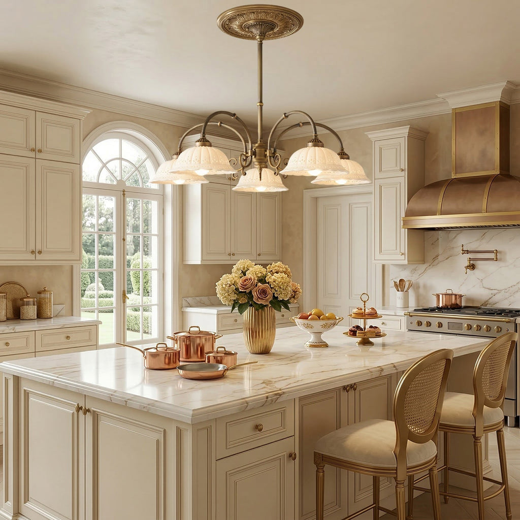 Clérachic five-light chandelier with white ceramic shades under a decorative ceiling rose, above a marble kitchen island with copper pans.