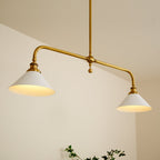 Clérachic pendant light seen from below at a steep angle, warm light pooling inside both cone shades against a plain cream wall.