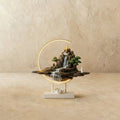Clérachic Hills-finish ceramic incense burner lamp, a bronze mountain waterfall scene glowing inside a warm circular LED ring.