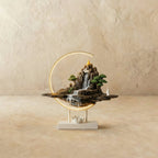 Clérachic Hills-finish ceramic incense burner lamp, a bronze mountain waterfall scene glowing inside a warm circular LED ring.