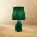 The Clérachic ceramic table lamp in green, paired with a matching pleated fabric shade, shown unlit.