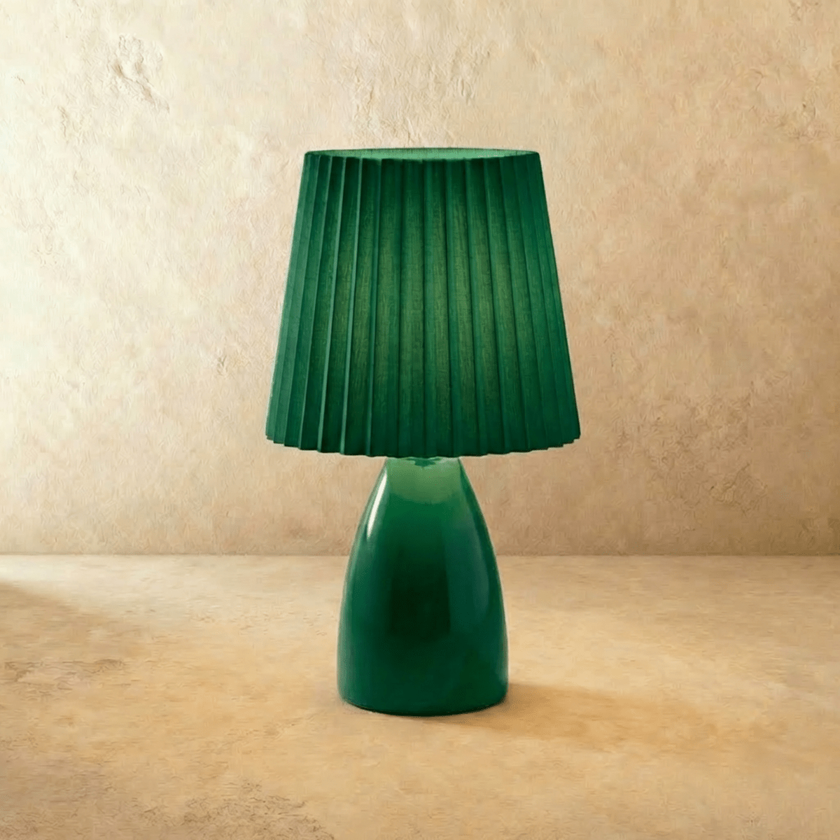 The Clérachic ceramic table lamp in green, paired with a matching pleated fabric shade, shown unlit.