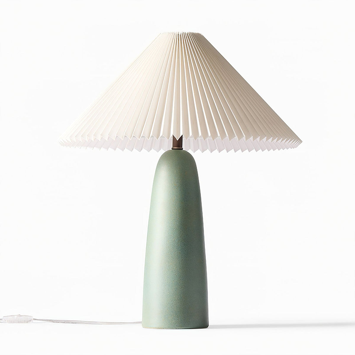 A tall green Clérachic table lamp with a matt ceramic base and wide pleated shade, unlit on white, with an in-line switch on the cord.