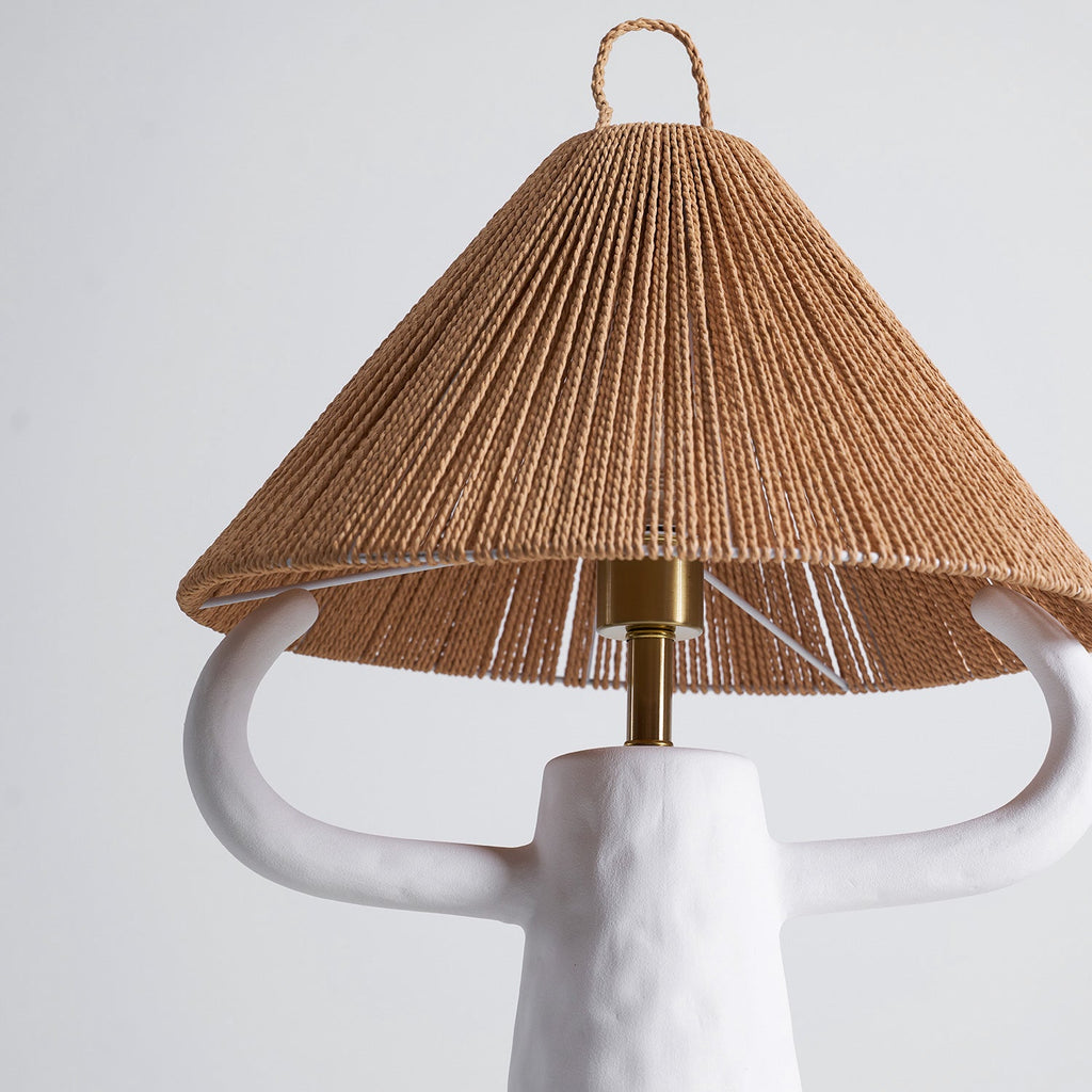 Close view of the white lamp's arms and brass stem under the woven rope shade, on this Clérachic table light.