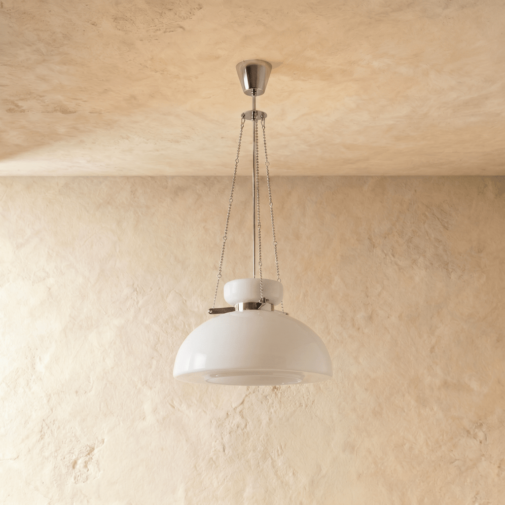 Clérachic white glass dome pendant on slim chains and a chrome canopy, switched off in front of a plaster wall.