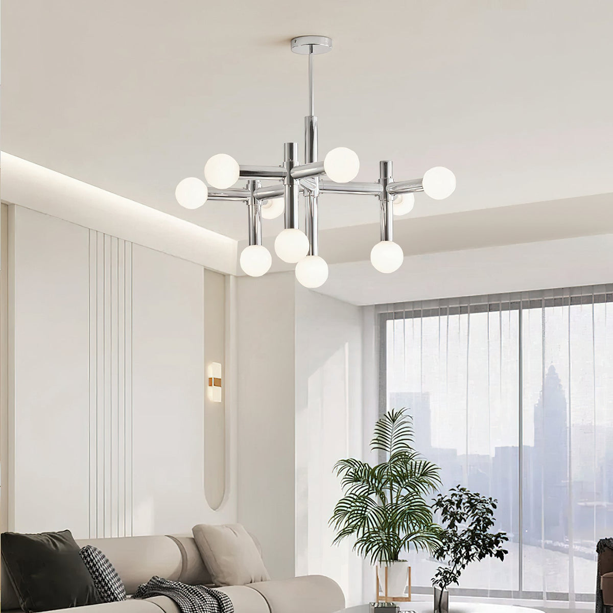 Clérachic chrome chandelier in a living room with cove lighting, a tall plant and a city view through the window.