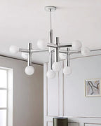 Portrait view of the Clérachic chandelier, its ten spheres glowing against a white panelled wall with a small framed print.